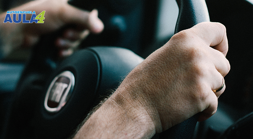 Imagen de unas manos de una persona agarrando un volante del coche