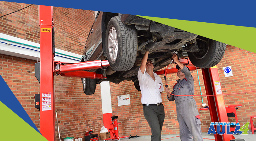 Coche subido en elevador de taller mecánico