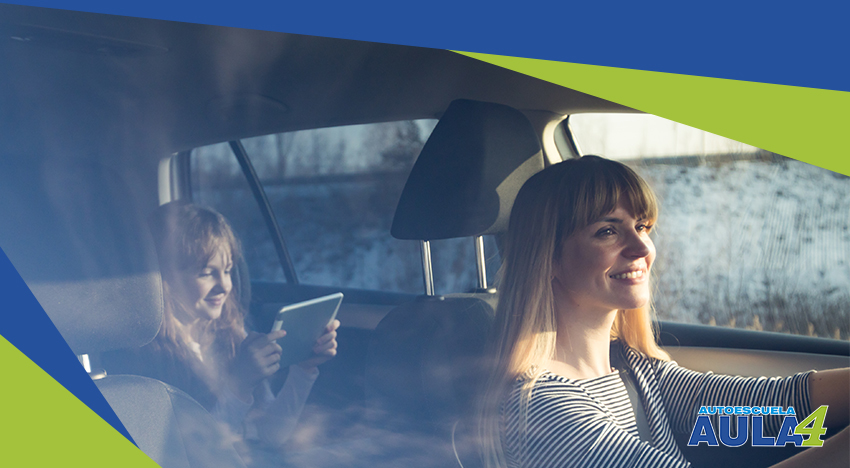 madre conduciendo el coche con su hija sentada detras